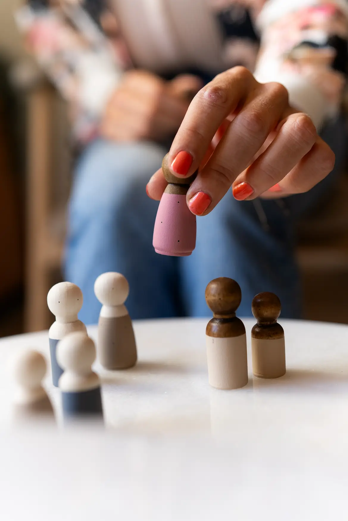 Handen die houten figuren op tafel plaatsen